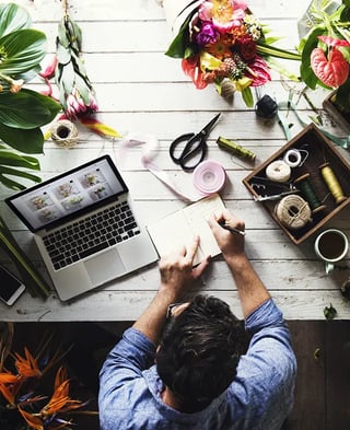 florist-top-view-laptop-guy-writing